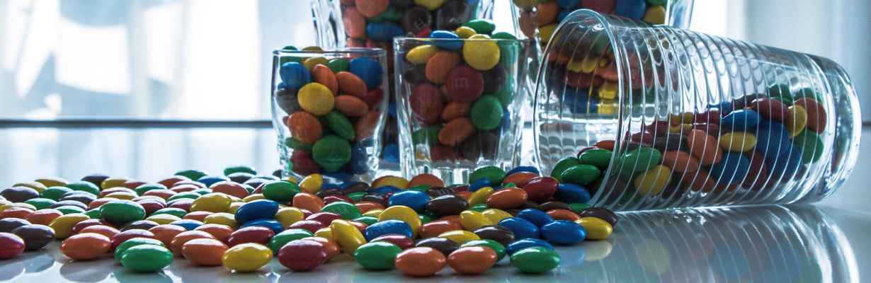 M&M Candies in cups scattered on table